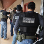 U.S. Marshals Fugitive Task Force officers in tactical gear during a fugitive arrest operation