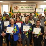 This image captures the joyful and celebratory atmosphere of the Jamaican citizenship ceremony at the New York consulate. The vibrant smiles, the waving flags, and the official certificates all symbolize the profound significance of this event for the new citizens